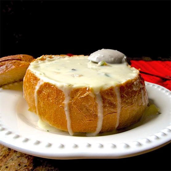 Thick and creamy clam chowder served in a sourdough bowl.