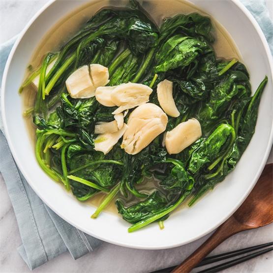 The tender spinach is served in a rich and garlicky broth.