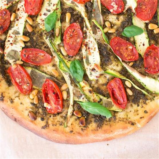 Vegan pizza with pesto, courgette and tomatoes