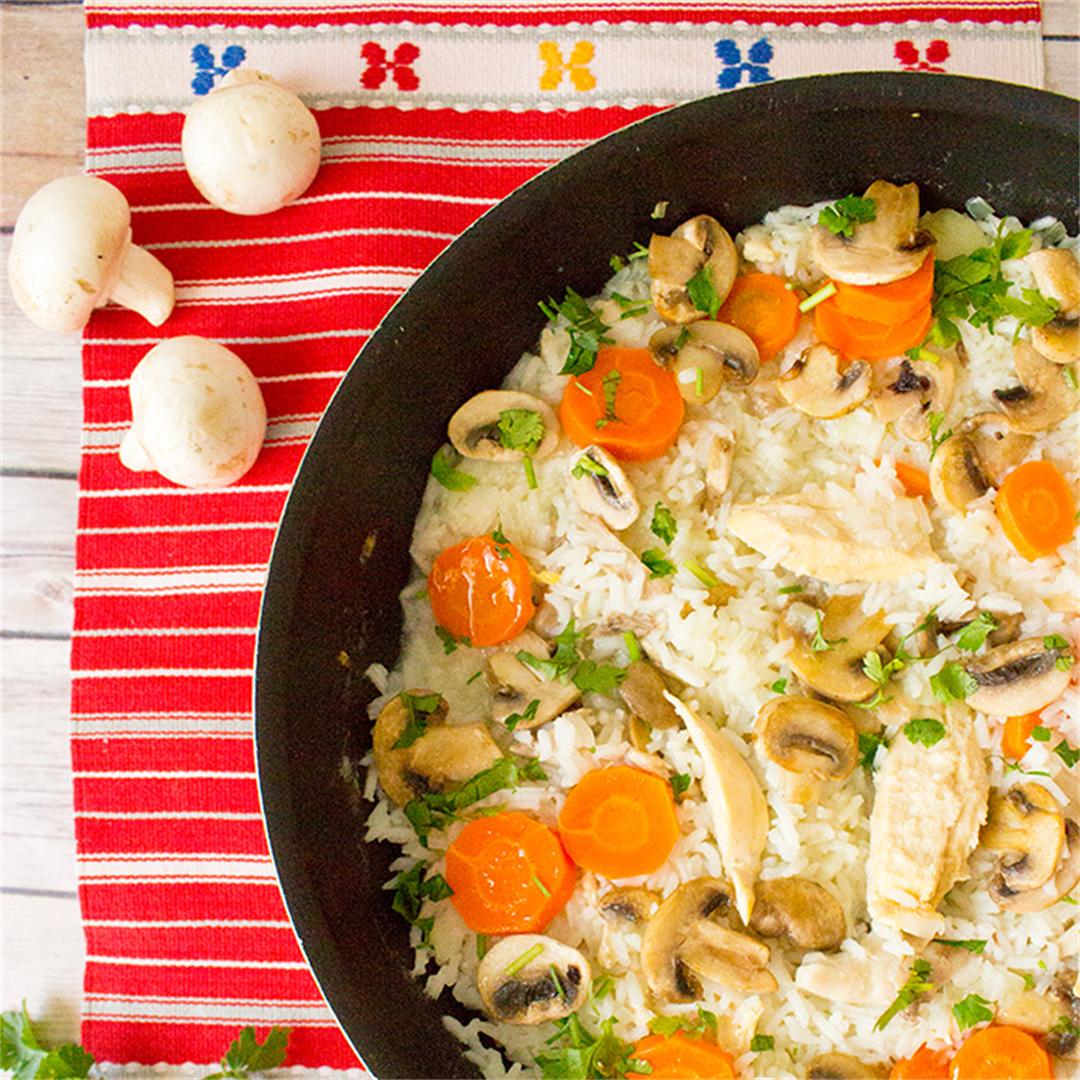 Rice with chicken, mushrooms, carrots, topped with parsley.