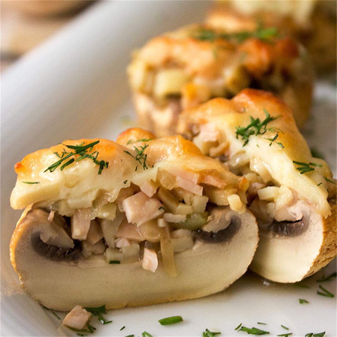Mushrooms stuffed with ham and cheese, garnished with dill.