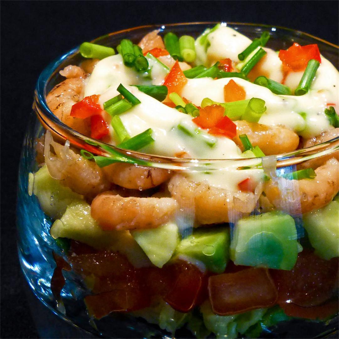 Lemony shrimp salad with avocado and tomato in small glasses