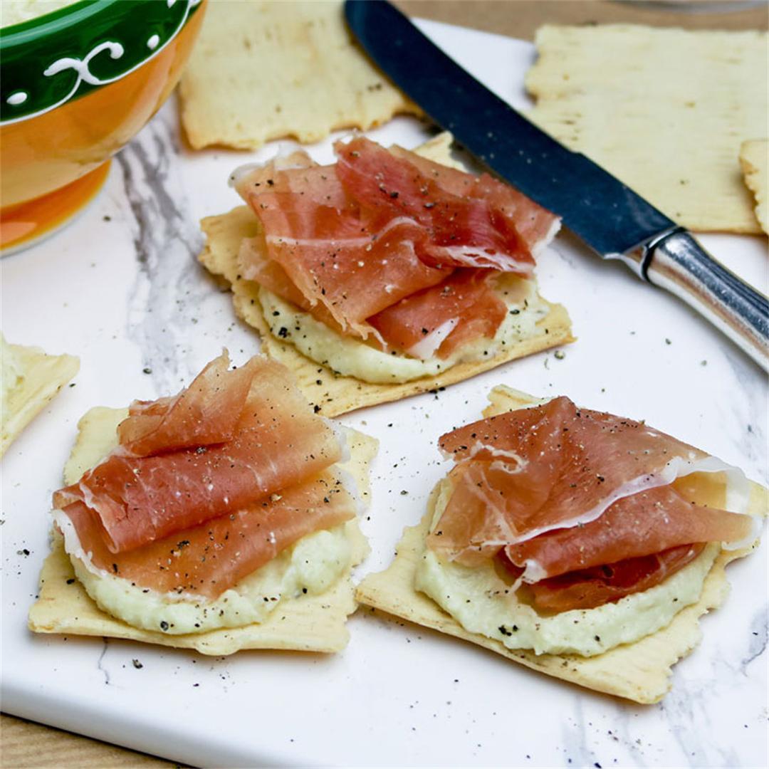 Crackers with creamy artichoke spread and Spanish serrano ham