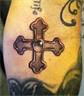 Iron Cross tattoo (symbolizes courage). Placement: inside elbow in crease